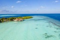 Aerial view of the Maldivian island with wooden houses on a   shallow water of a reef in the Indian Ocean Royalty Free Stock Photo