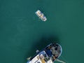 Aerial view of a man in a boat rowing among the boats moored in a harbor Royalty Free Stock Photo