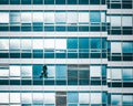 Aerial view of a man hanging on a rope and cleaning the windows of a high-rise building Royalty Free Stock Photo