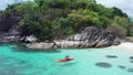 Aerial view of man kayaking in crystal clear sea water near Koh Kra island in Thailand