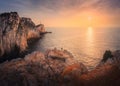 Aerial view of man on mountain peak, lighthouse, sea at sunset Royalty Free Stock Photo