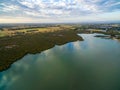 Aerial view of mangroves and meadows near ocean coastline at sunset in Australia.