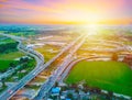 Aerial view of a massive highway intersection, Highway to city transport traffic road with vehicle movement at sunset.