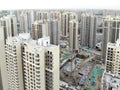 Aerial view of massive identical buildings site in construction with tower crane.