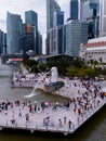 Aerial view of Merlion with crowded tourists. The icon of Singapore with tall skyscrapers on the background