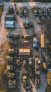 Aerial view of a military convoy arrayed on a remote dirt road at dusk, showcasing a systematic arrangement of tents and