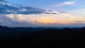 Aerial view of misty tropical forest with warm glow of sunrise in the morning. Top view from drone of beautiful mountain tropical