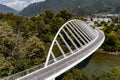 Aerial view of a modern arch shaped design pedestrian bridge over the Ticino river in Switzerland