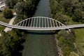 Aerial view of a modern arch shaped design pedestrian bridge over the Ticino river in Switzerland