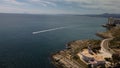 Aerial view of modern buildings of coastal Valencia and speedboa trails in the sea