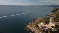 Aerial view of modern buildings of coastal Valencia and speedboat trails in the sea