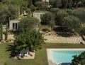 Aerial view of a modern country house made of raw concrete on a plot full of olive trees