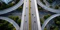 Aerial view of a modern urban highway interchange with multiple elevated roads and light traffic surrounded by green trees and Royalty Free Stock Photo