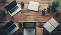 overhead view of a wooden table with laptops notebooks plants coffee cups and office supplies arranged for a work session Royalty Free Stock Photo
