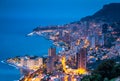 Aerial view of Monaco - Monte-Carlo at dusk, cityscape with night illumination, mountain, skyscrapers, mediterranean sea Royalty Free Stock Photo