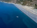 Aerial view of moored boat floating on a transparent sea. Nonza black beach. Corsica. France