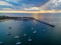 Aerial view of moored boats and long pier at sunset. Mornington