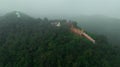 Aerial view at morning mist Wat Phra That Doi Phra Chan. and Daibutsu Buddha on the greenery mountain in the rainforest north of