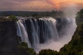 Aerial view of Mosi-Oa-Tunya Falls waterfall in Zambia during sunset with birds flying around