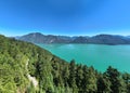 Aerial view of a mountain range with a lake in the foreground, surrounded by lush green trees Royalty Free Stock Photo