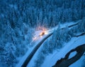 Aerial view of mountain road in fairy forest in snow and snowplow