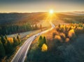 Aerial view of mountain road in forest at sunset in autumn