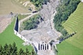 Aerial view of mountain stream in the Austrian Alps blocked after a massive mudflow with excavator and truck working to clean up