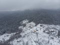 Aerial view of a Mountain Village with Hills Covered in Snow and Pine Forest in Winter. Yaremche, Ukraine. Flying over Royalty Free Stock Photo