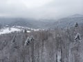 Aerial view of a Mountain Village with Hills Covered in Snow and Pine Forest in Winter. Yaremche, Ukraine. Flying over Royalty Free Stock Photo