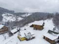 Aerial view of a Mountain Village with Hills Covered in Snow and Pine Forest in Winter. Yaremche, Ukraine. Flying over Royalty Free Stock Photo