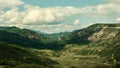 Aerial view of a mountainous green landscape with lush nature in cloudy sky background Royalty Free Stock Photo