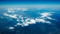 Aerial view of mountains under the clouds and blue sky. View from a plane window. Beautiful landscape Royalty Free Stock Photo