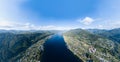 Aerial view of mouth at wide Teletskoye lake in the Altai Mountains by the blue water, sky with white clouds, green trees on the Royalty Free Stock Photo