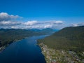 Aerial view of mouth at wide Teletskoye lake in the Altai Mountains by the blue water, sky with white clouds, green trees on the Royalty Free Stock Photo