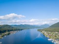 Aerial view of mouth at wide Teletskoye lake in the Altai Mountains by the blue water, sky with white clouds, green trees on the Royalty Free Stock Photo