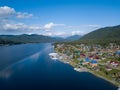 Aerial view of mouth at wide Teletskoye lake in the Altai Mountains by the blue water, sky with white clouds, green trees on the Royalty Free Stock Photo