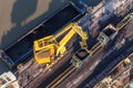 Aerial view of moving crane with a heap of coal next to the coal