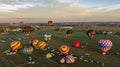 Aerial View of Multiple Hot Air Balloons Floating Up During a Morning Launch on a Sunny Summer Day