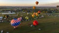 Aerial View of Multiple Hot Air Balloons Floating Up During a Morning Launch on a Sunny Summer Day