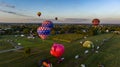 An Aerial View of Multiple Hot Air Balloons Floating Up During a Morning Launch on a Sunny Summer Day