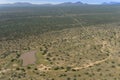 Aerial view Namibian landscape with waterhole,long roads and acacia tree bush scattered across land.