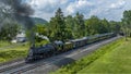 Aerial View of Narrow Gauge Steam Passenger Train, Approaching, Blowing Smoke, Passing Coal Hoppers