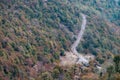 Aerial view of a narrow road passing through the forest covered in fall colours Royalty Free Stock Photo