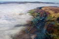 Aerial view of a narrow, winding mountain road on a hillside above a fog filled valley Royalty Free Stock Photo