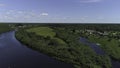 Aerial view of natural landscape with a river flowing among the small town or village. Shot. Flying above the green Royalty Free Stock Photo