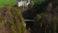 Aerial view Neuschwanstein Castle and bridge Marienbrucke across Pollat gorge in Ammergau Alps. View of famous