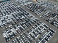 Aerial view of new cars stock at factory parking lot. Above view cars parked in a row. Automotive industry. Logistics business. Royalty Free Stock Photo