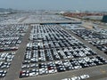 Aerial view of new cars stock at factory parking lot. Above view cars parked in a row. Automotive industry. Logistics business. Royalty Free Stock Photo