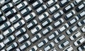 Aerial view of new cars stock at factory parking lot. Above view cars parked in a row. Automotive industry. Logistics business. Royalty Free Stock Photo