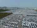 Aerial view of new cars stock at factory parking lot. Above view cars parked in a row. Automotive industry. Logistics business. Royalty Free Stock Photo